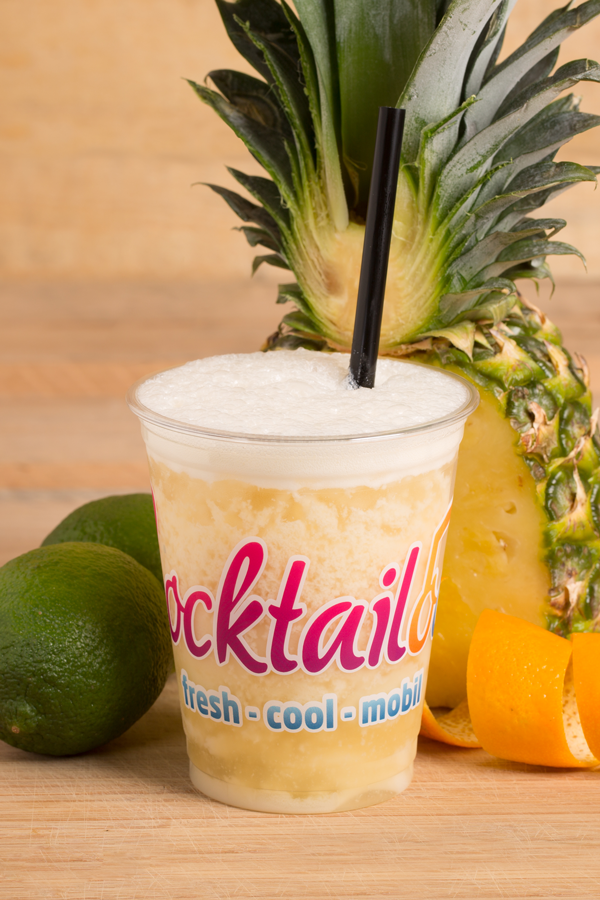 Abbildung des Cocktails: Gelb-Weißer Cocktail in Plastikbecher mit Cocktailooo-Logo. Verziert mit Limetten und Ananas.