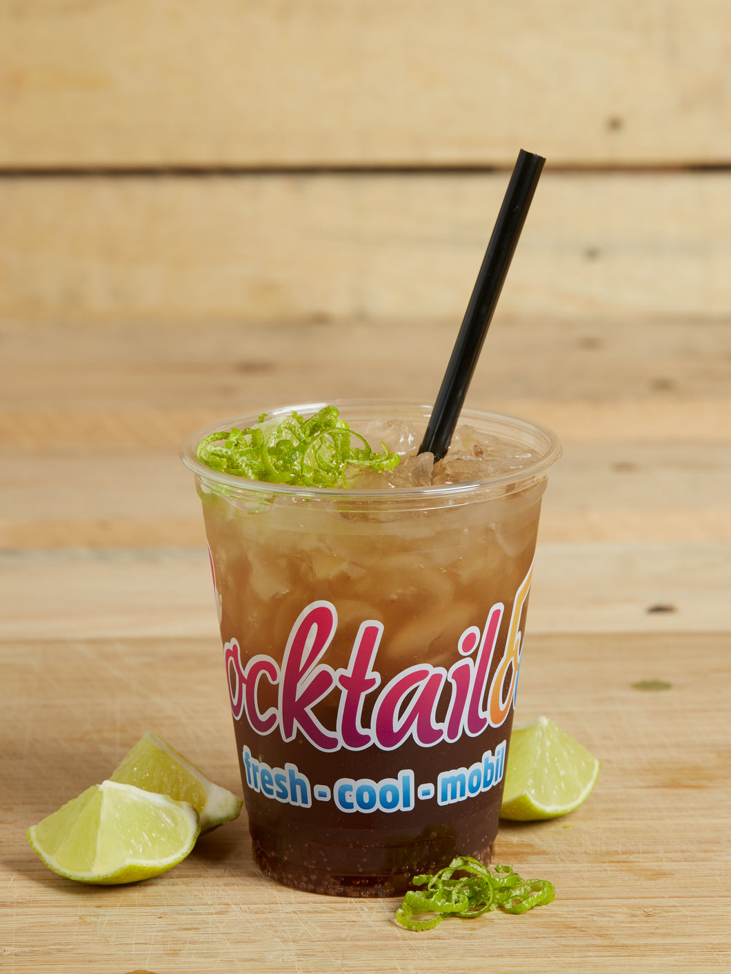 Abbildung des Cocktails: Braun-Durchsichtiger Cocktail in Plastikbecher mit Cocktailooo-Logo. Verziert mit Limetten.
