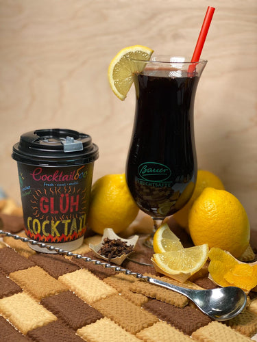 Abbildung des Glüh-Cocktails: Cocktailglas mit dunkelroter Flüssigkeit. Daneben ein To-Go Becher mit dem Cocktailooo Logo und der Aufschrift 